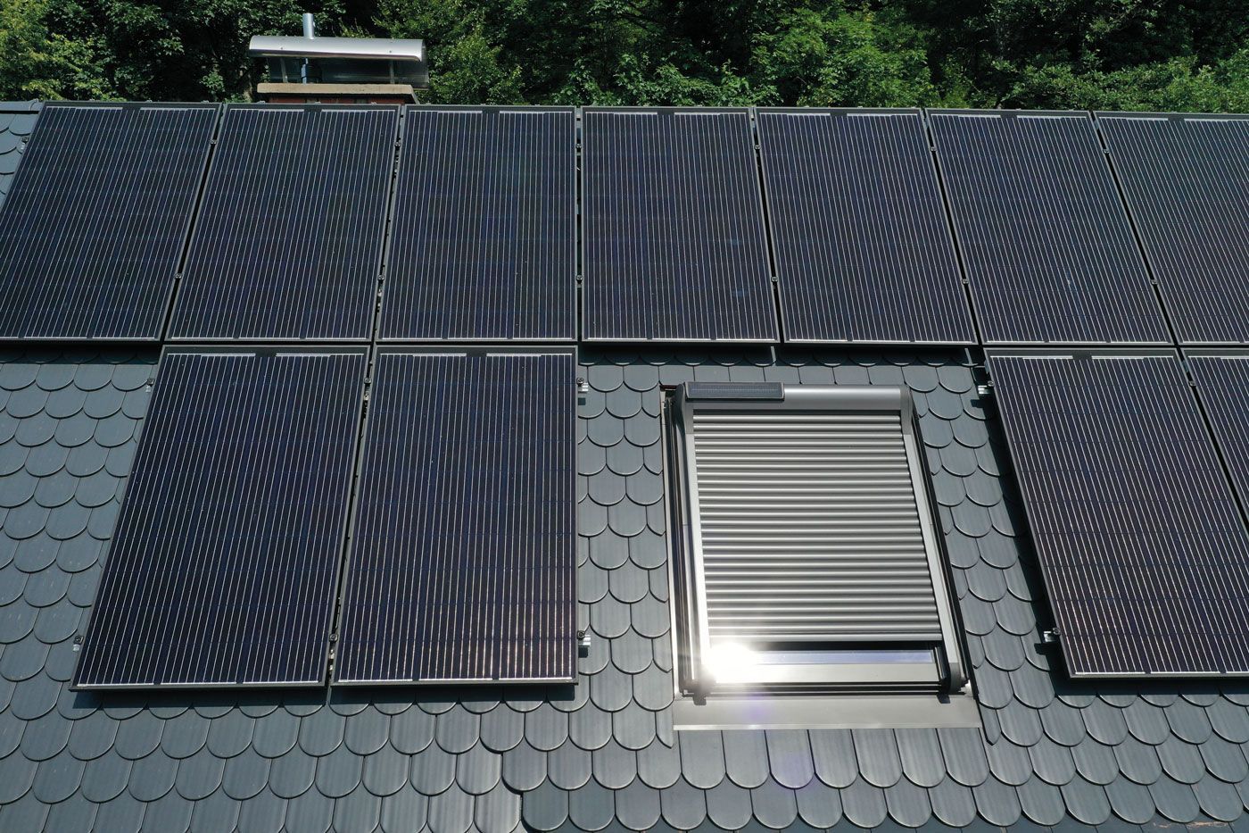 Ein Dach mit vielen Sonnenkollektoren und einem Fenster
