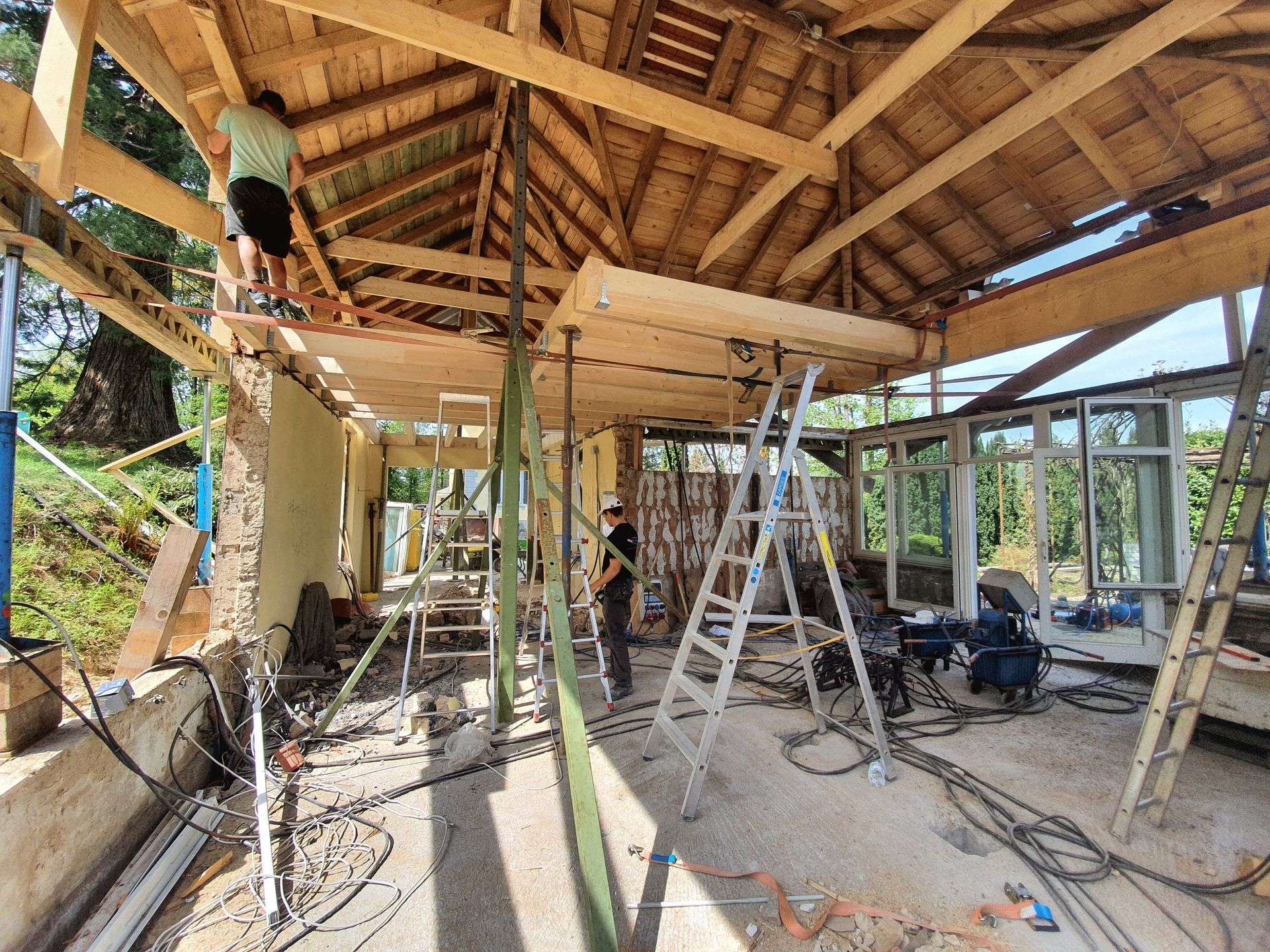 Ein Mann steht auf einer Leiter in einem im Bau befindlichen Gebäude.