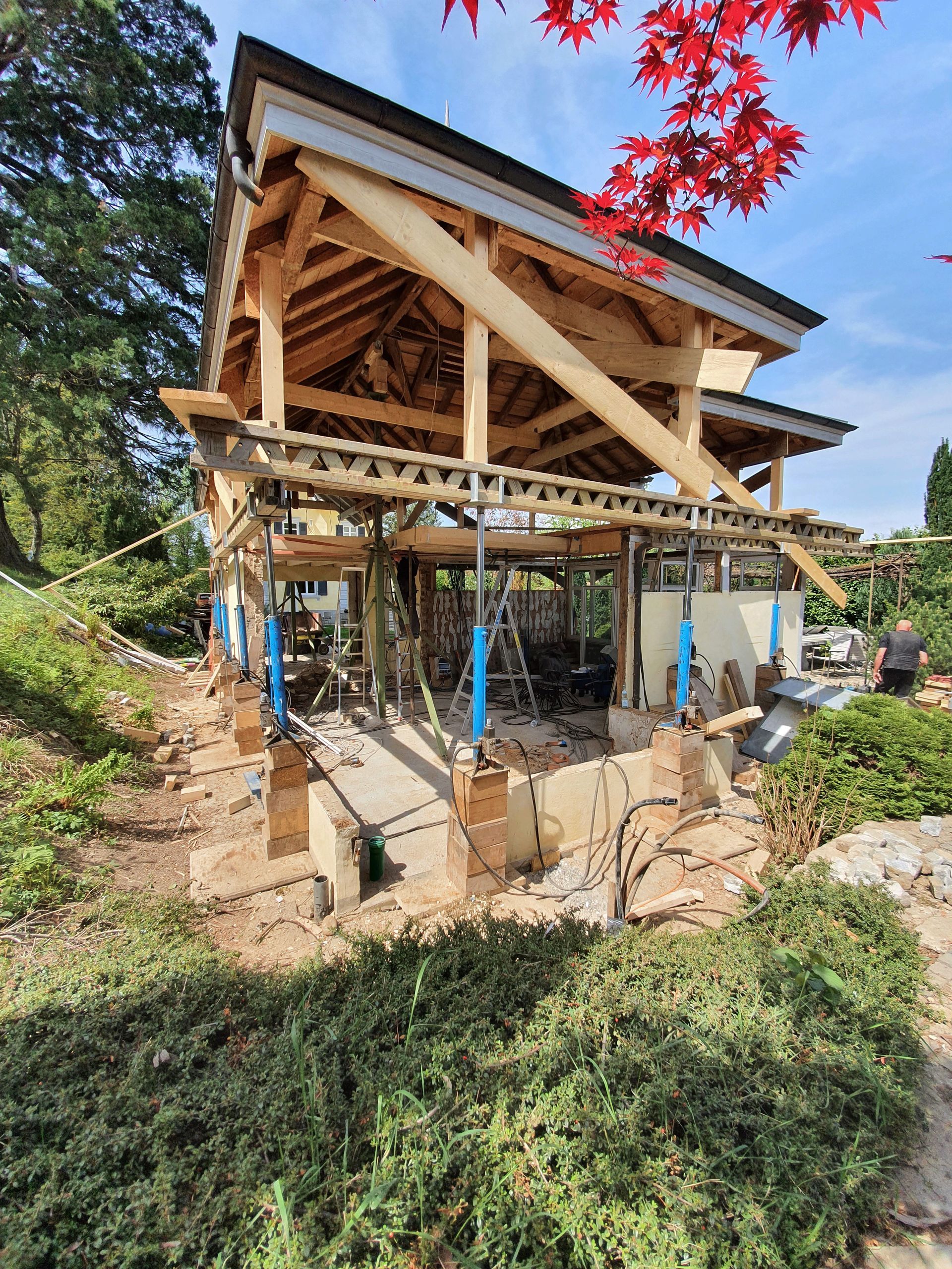 Mitten in einem Wald wird eine große Holzkonstruktion errichtet.