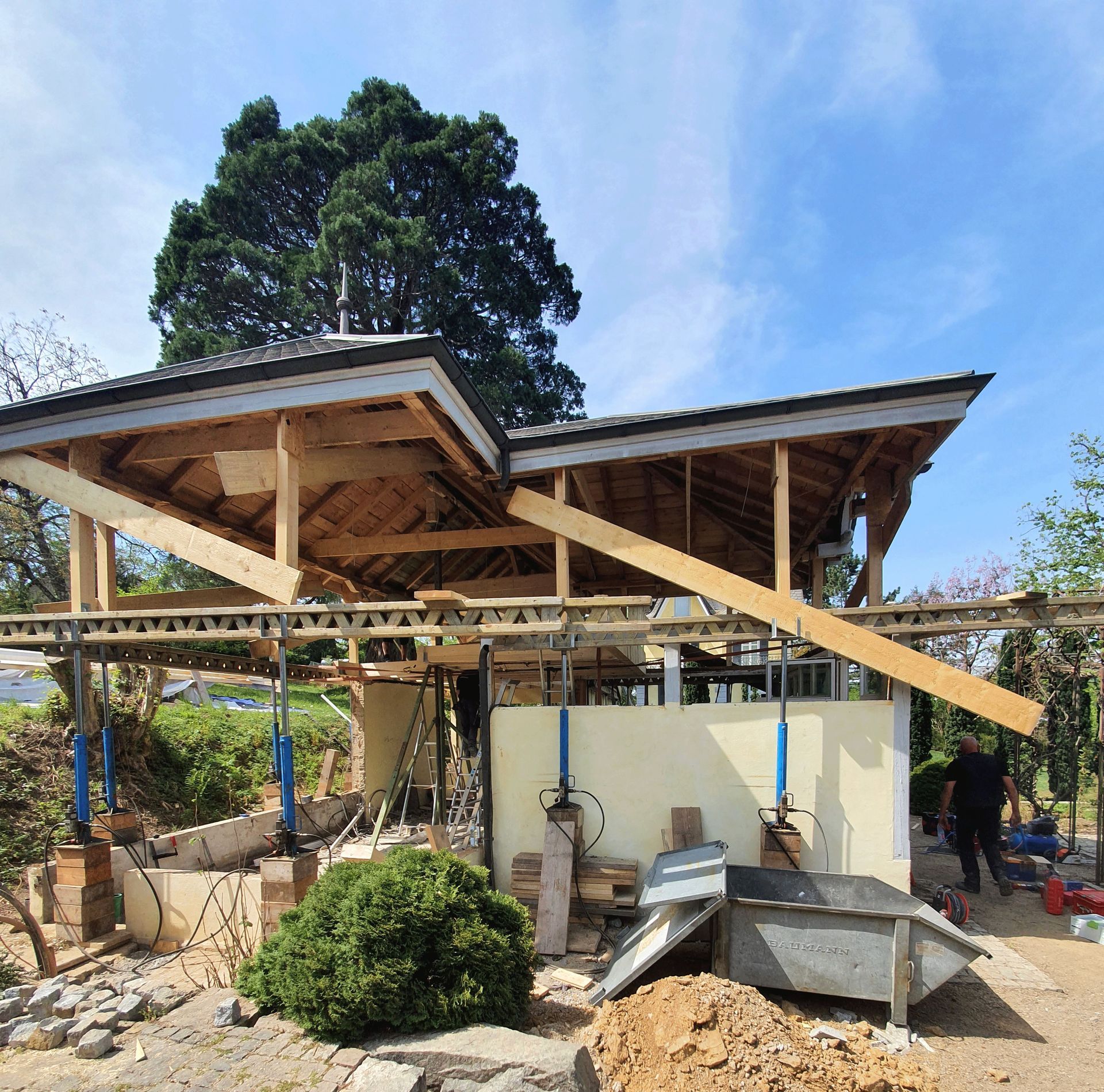 Ein im Bau befindliches Gebäude mit einem Baum im Hintergrund