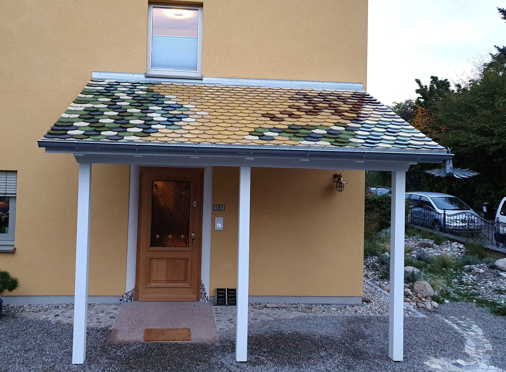 Ein gelbes Haus mit einer weißen Veranda und einer Holztür