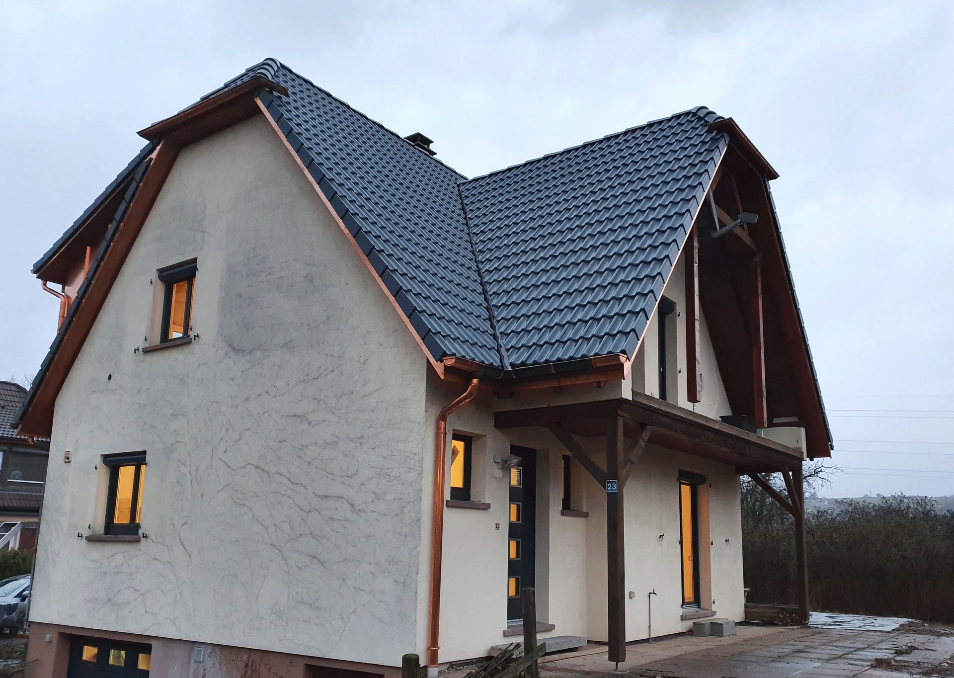 Ein weißes Haus mit blauem Dach und Kupferdachrinnen