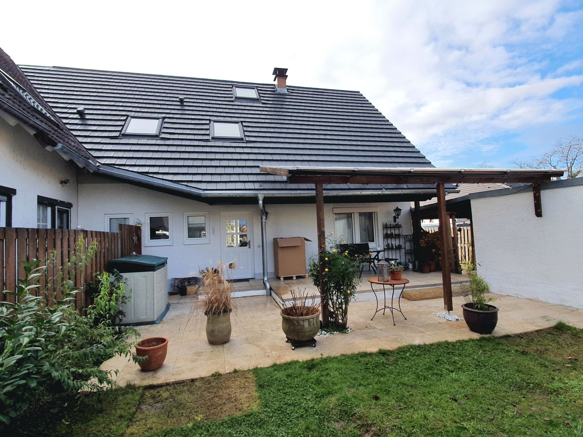 Ein Haus mit einer überdachten Terrasse davor.