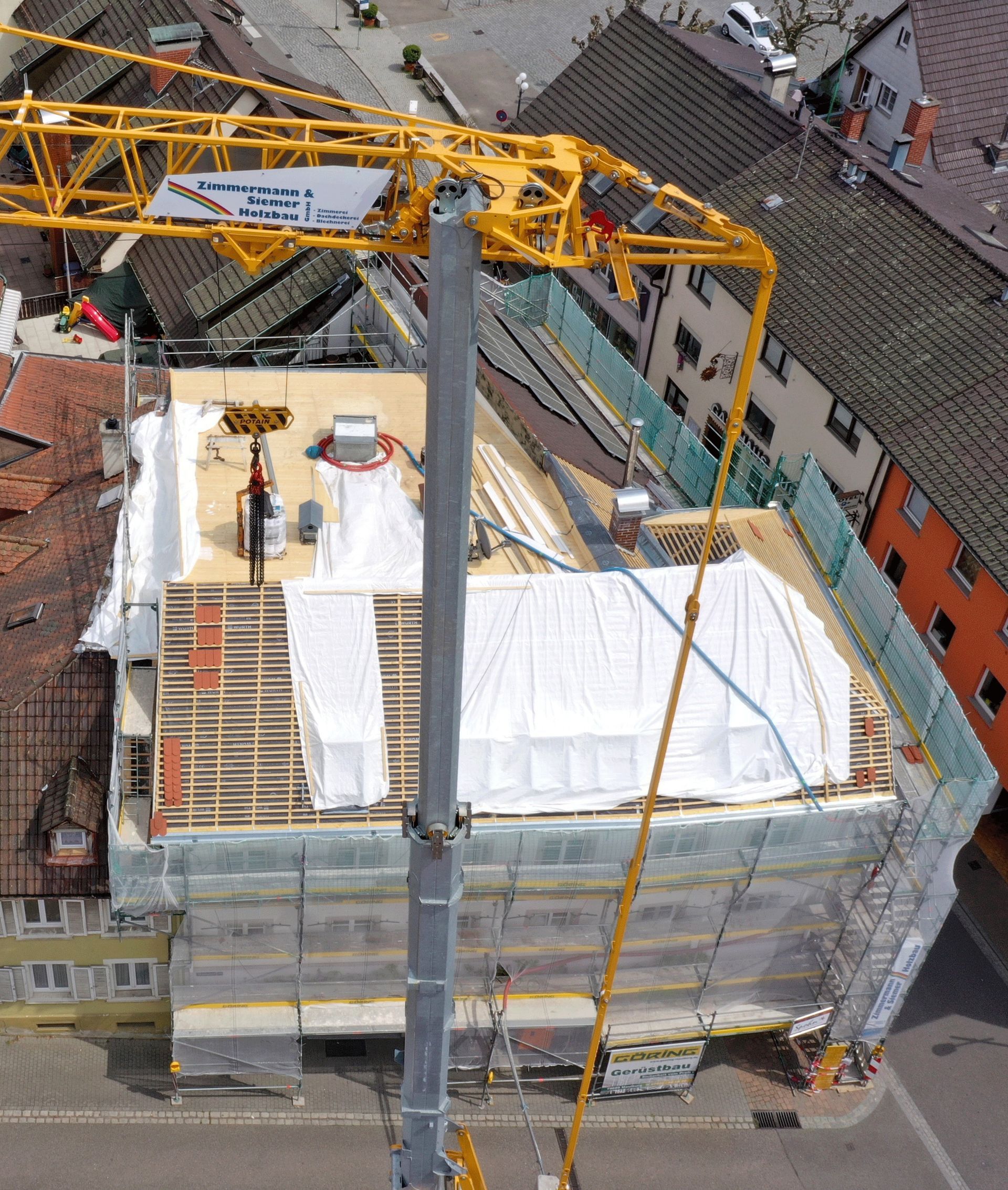 Eine Luftaufnahme eines im Bau befindlichen Gebäudes mit einem Kran auf der Oberseite