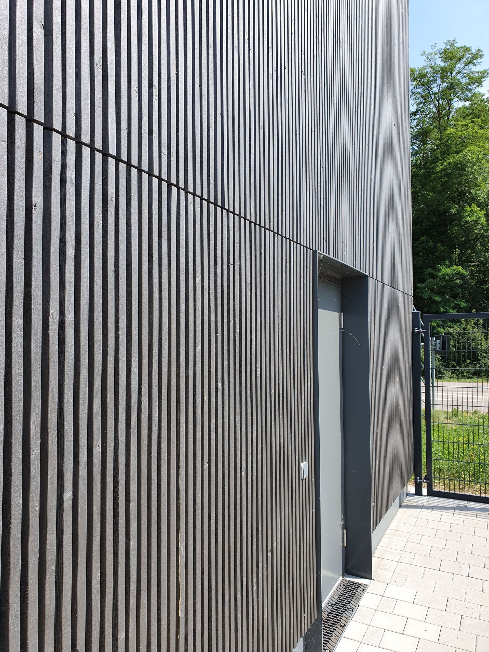 Eine Nahaufnahme eines Gebäudes mit einer Tür und einem Zaun.