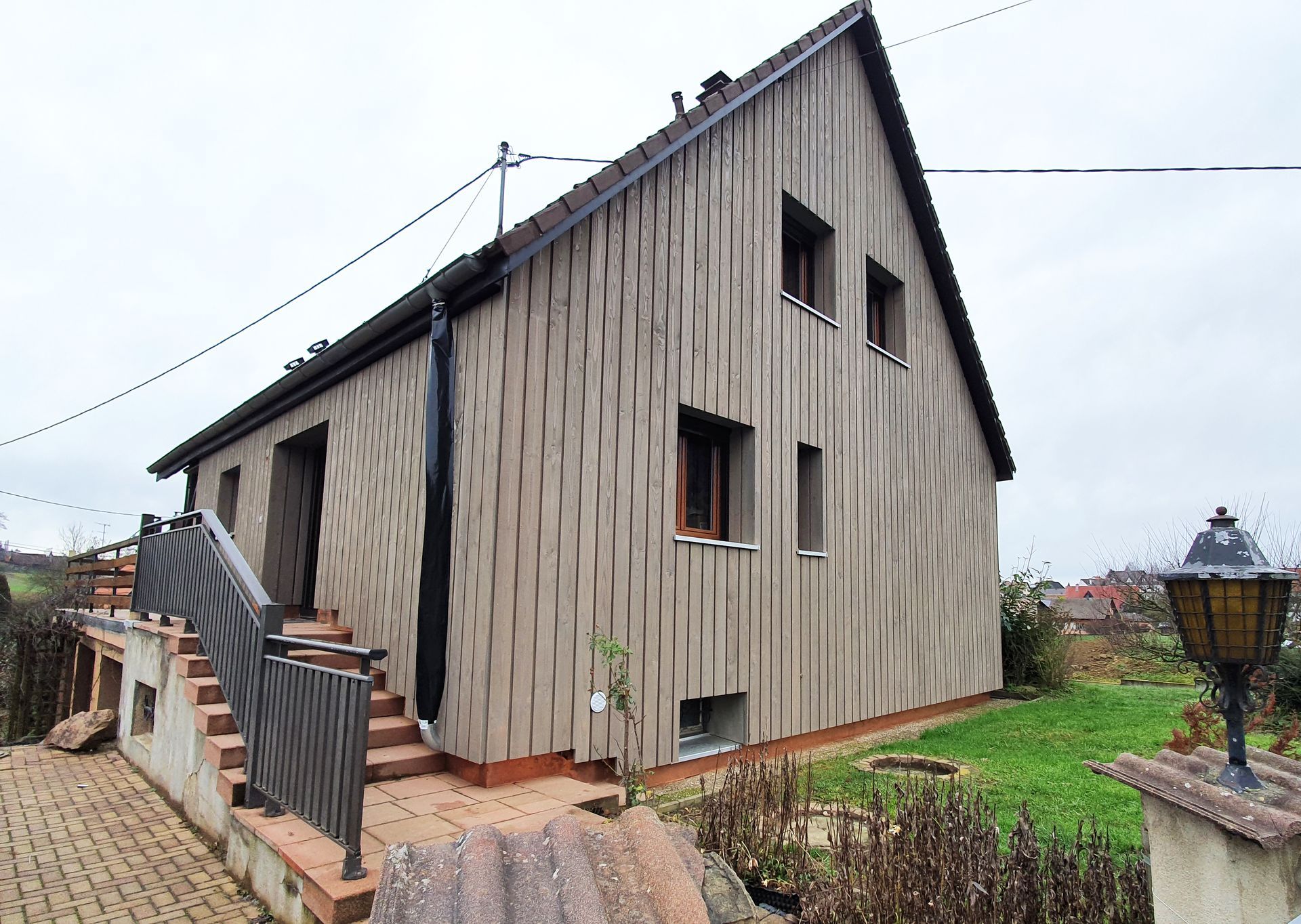 Ein Haus mit einer Holzverkleidung und einer Treppe, die nach oben führt.