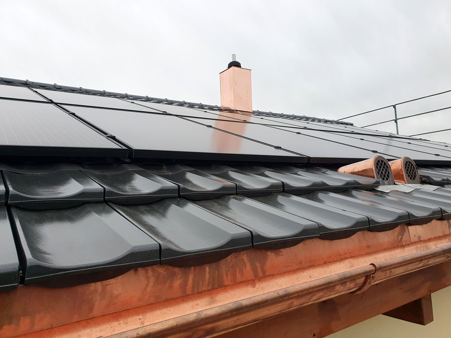 ein Dach mit einem Schornstein und Sonnenkollektoren darauf