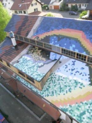 Eine Luftaufnahme eines Hauses mit einem Gemälde eines Regenbogens auf dem Dach