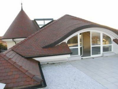 Ein Haus mit einem geschwungenen Dach und einem großen Fenster