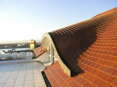 Ein rotes Ziegeldach mit einem Fenster an der Seite