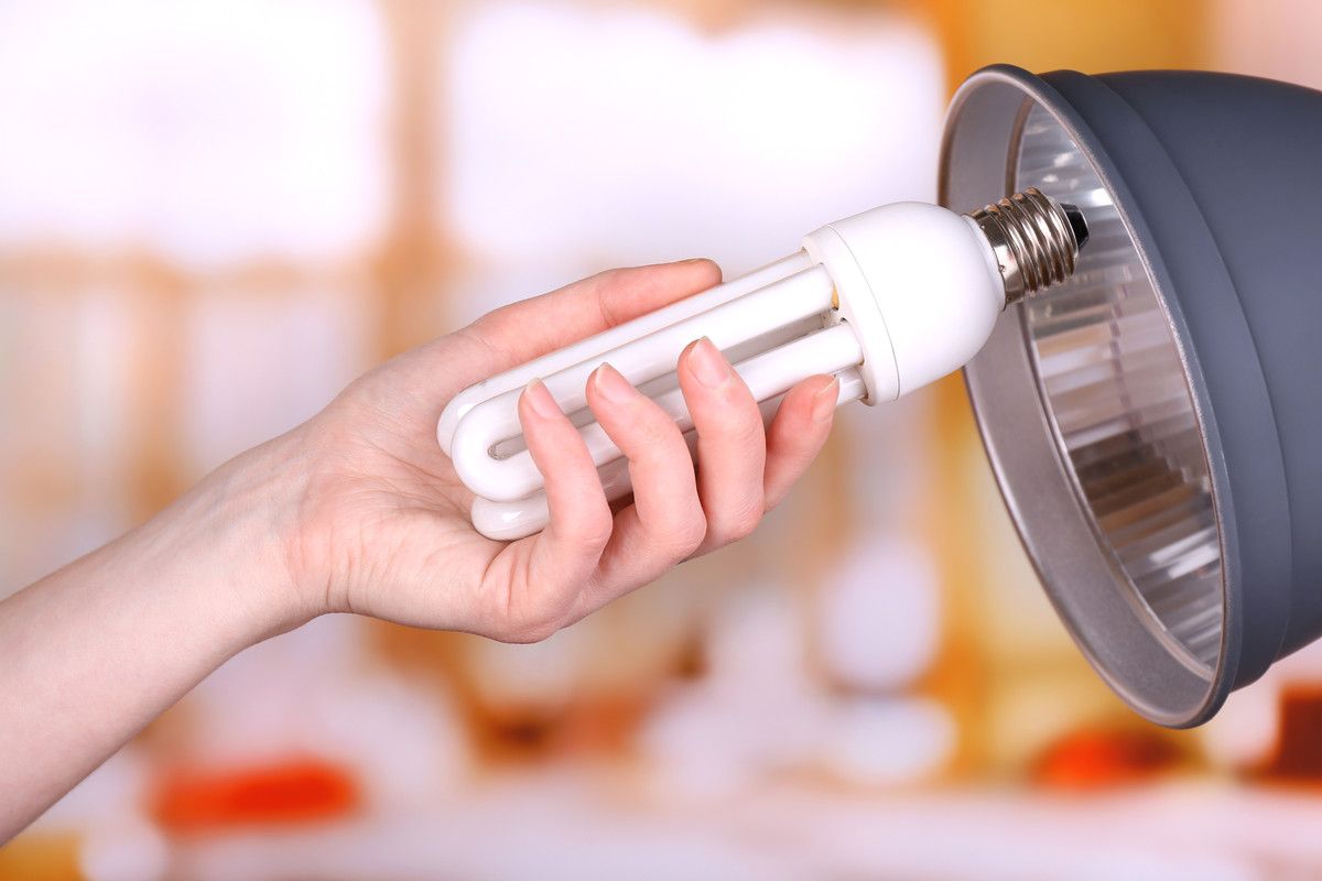 Main installant une ampoule