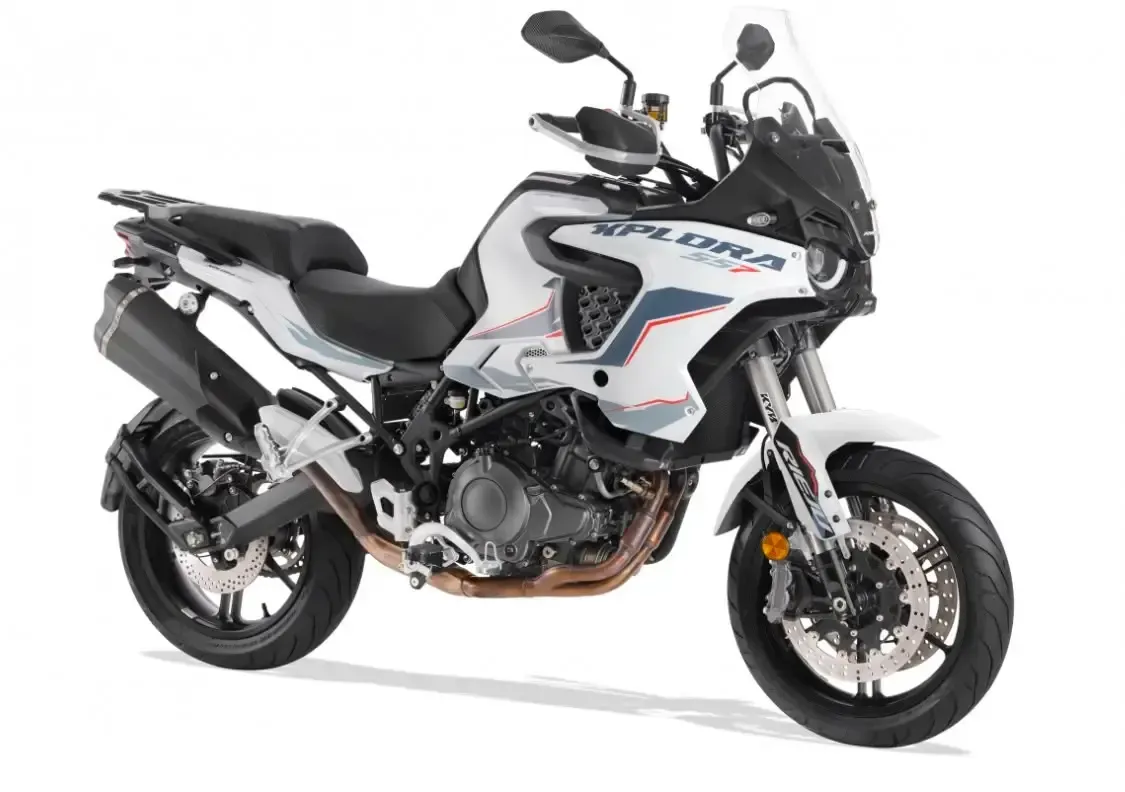 Motocicleta de aventura blanca con asiento y parabrisas negros, mostrada de perfil sobre un fondo blanco.