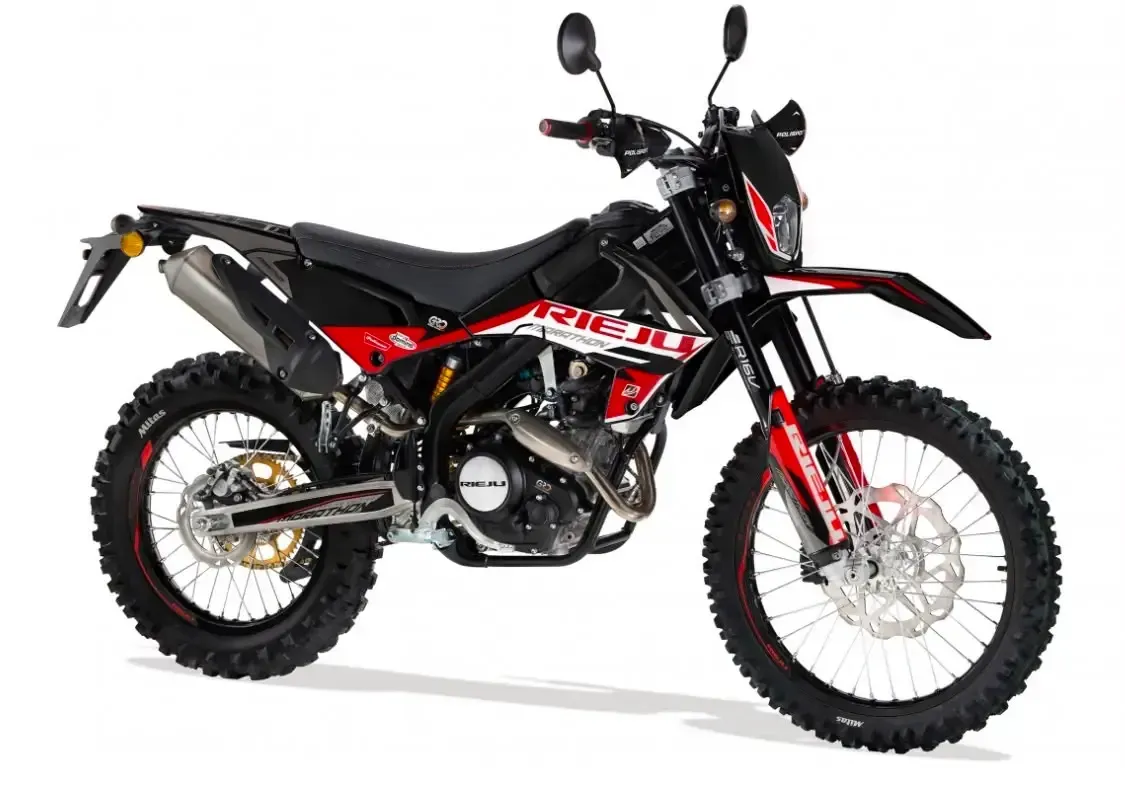 Motocicleta todoterreno negra y roja con neumáticos de tacos sobre un fondo blanco.