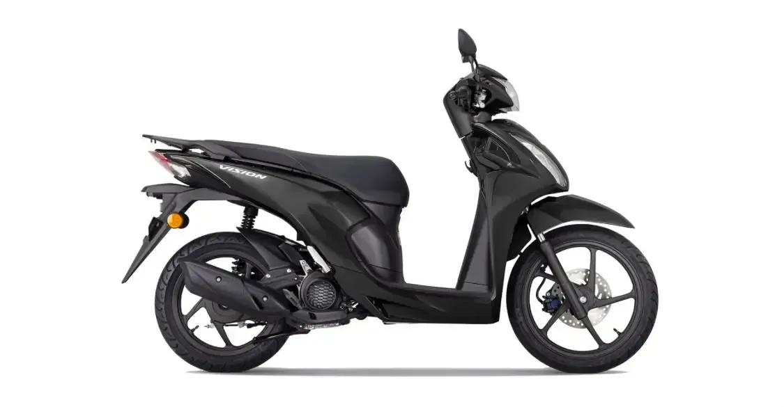 Motocicleta scooter negra vista de perfil sobre un fondo blanco.