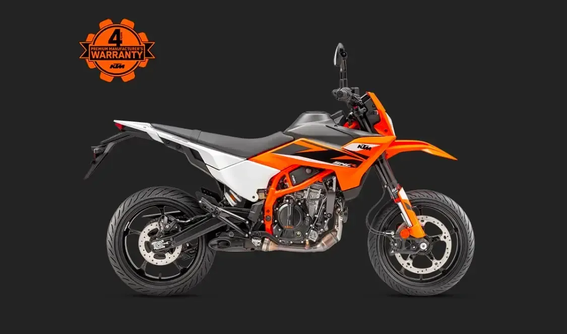 Moto de cross KTM naranja y negra vista lateral sobre un fondo oscuro.