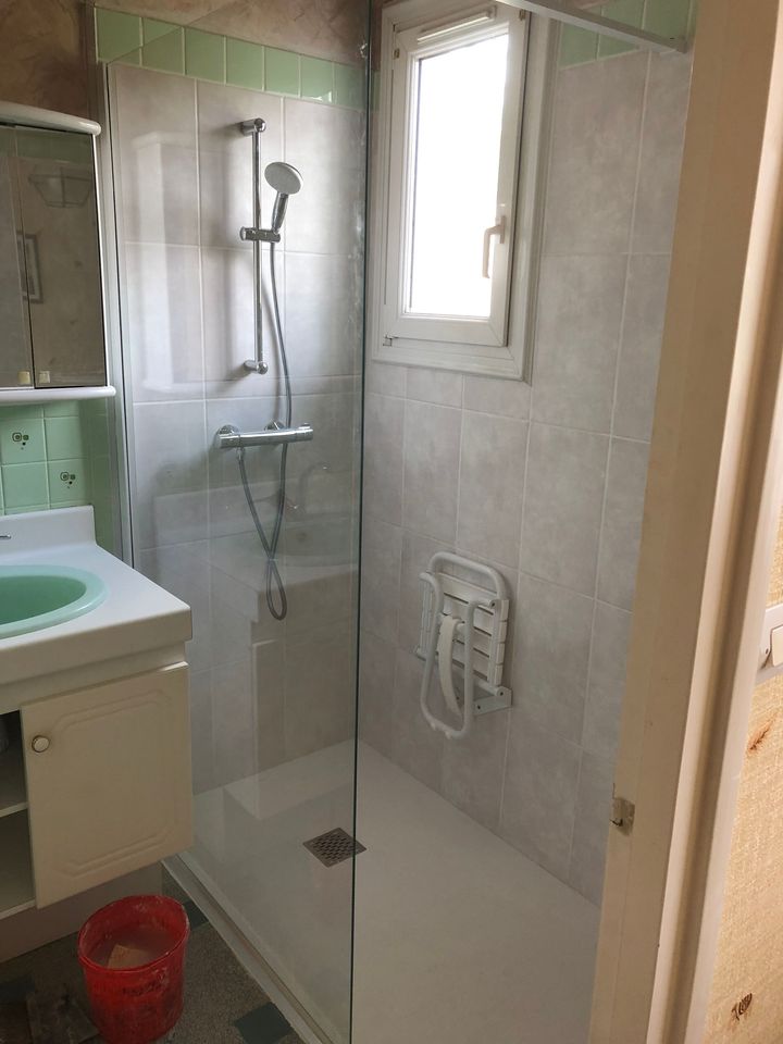 Une douche à l'italienne avec une fenêtre dans une salle de bains