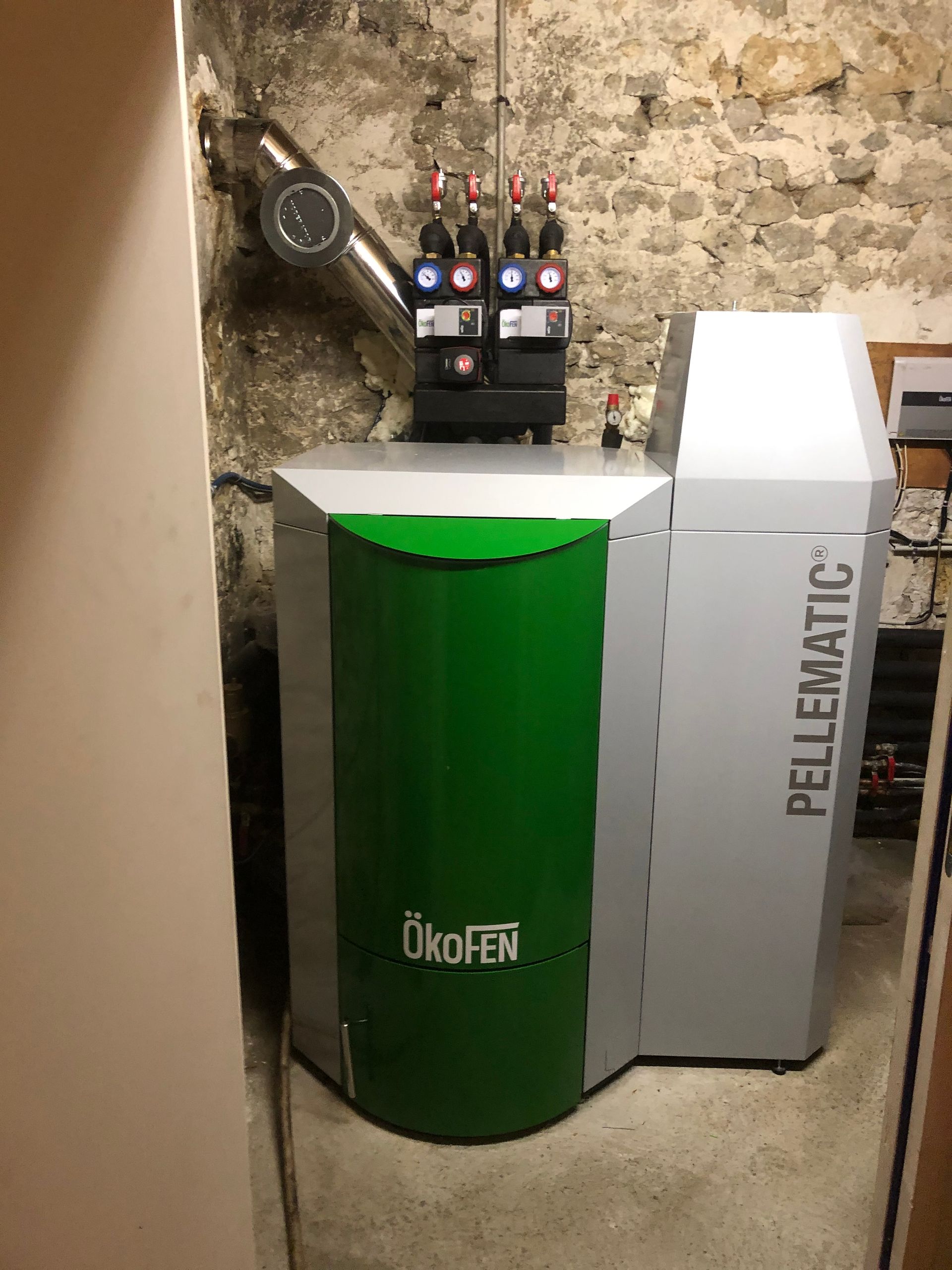 Une chaudière de couleur grise et verte installée dans la cave