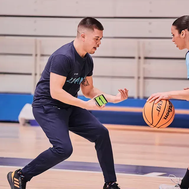 Un hombre está driblando una pelota de baloncesto Wilson en una cancha.