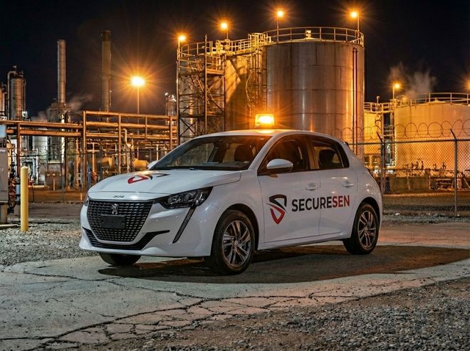 Une voiture de sécurité blanche Securesen garée sur un site industriel