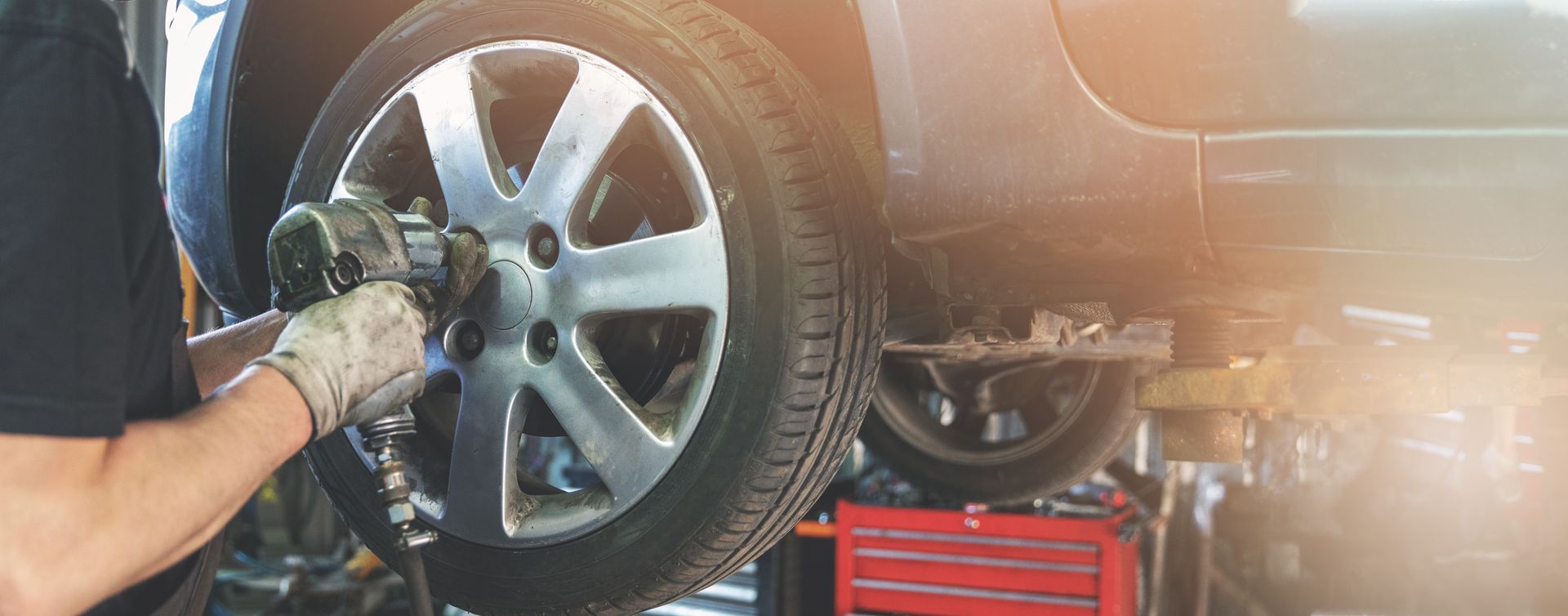 Un mécanicien utilise une clé à chocs pour retirer une roue de voiture dans un garage