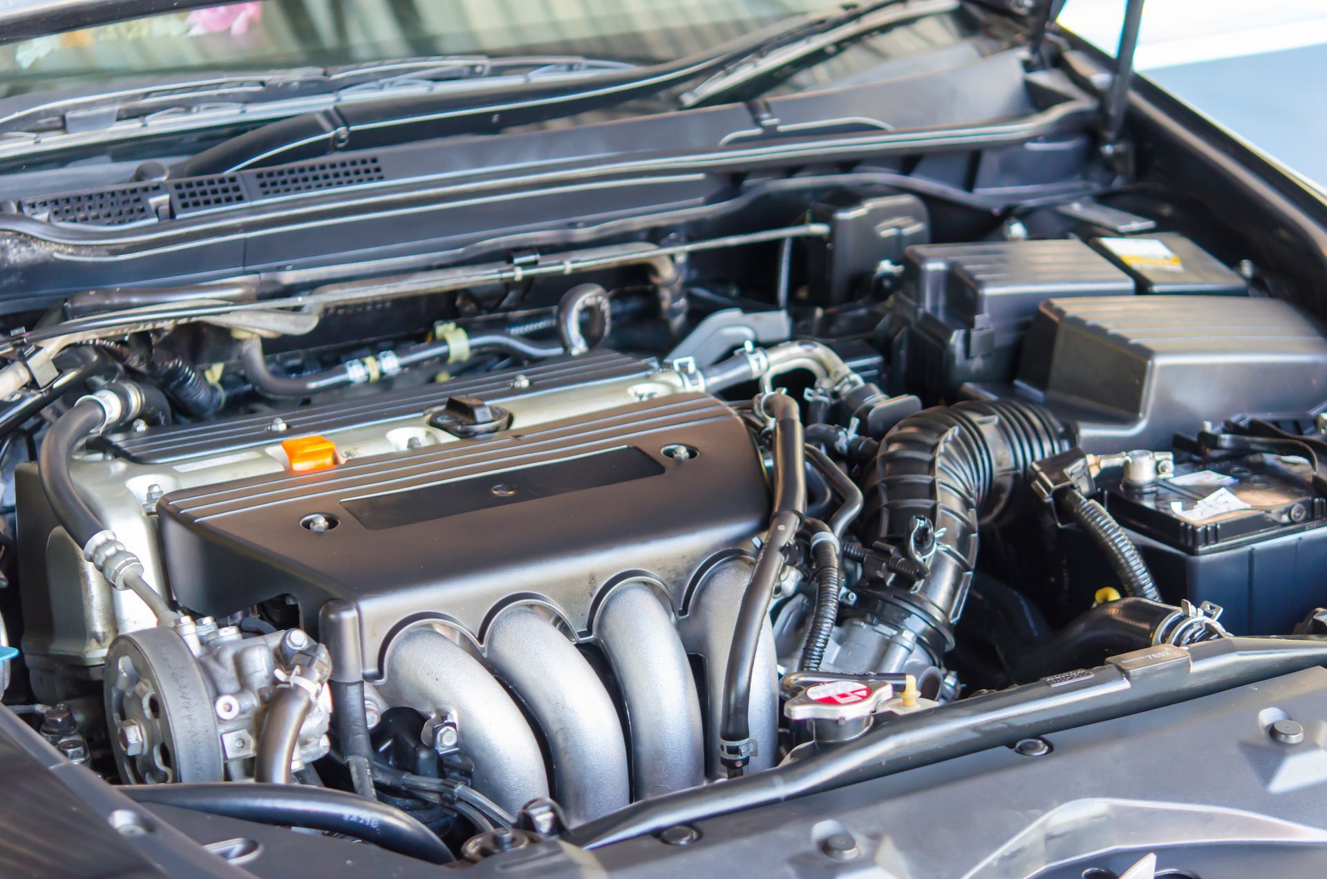 Compartiment moteur avec un collecteur d’admission argenté et des durites noires sous le capot