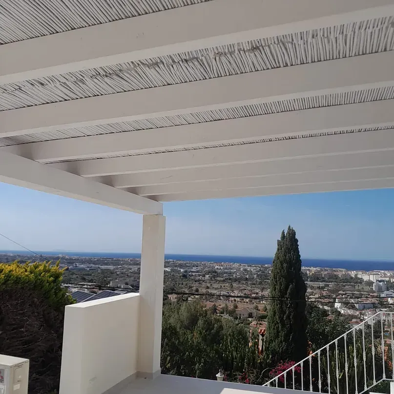 Un balcón con vista a una ciudad y al océano.