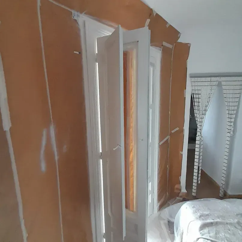 Un dormitorio con una cama y una puerta que está abierta.