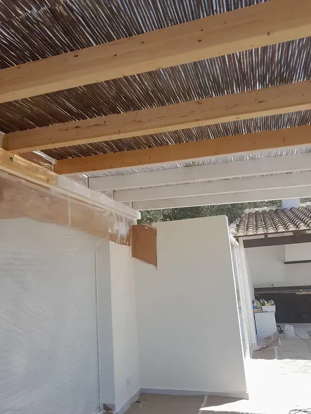 Un edificio blanco con techo de madera y pared blanca