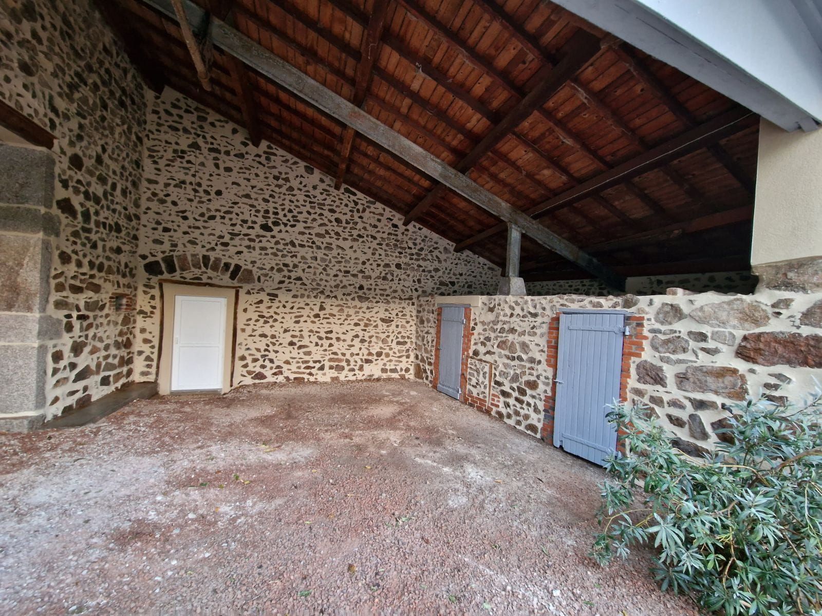 Cour abritée avec des murs en pierre rénovés.