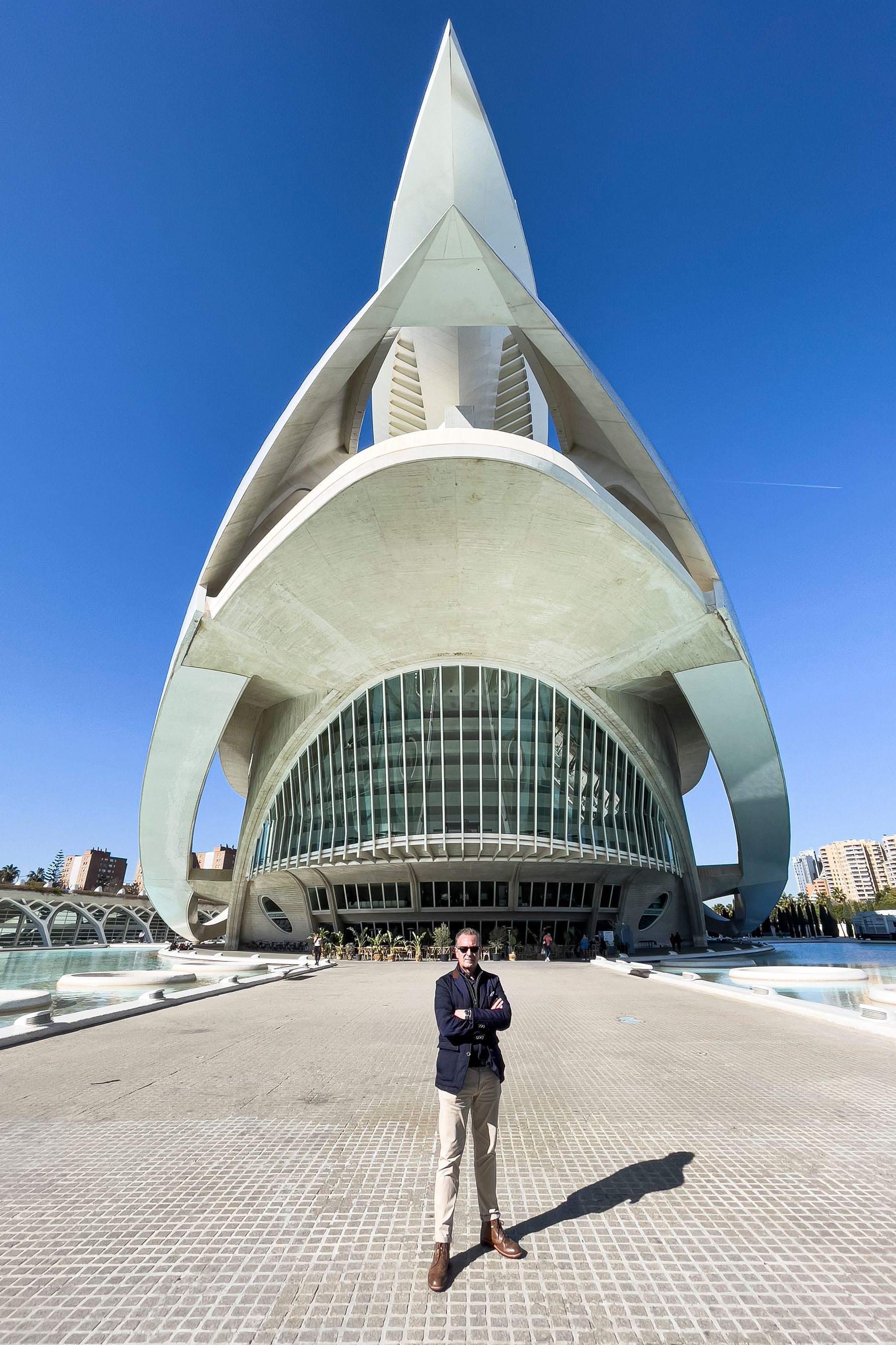 Un hombre está parado frente a un gran edificio.