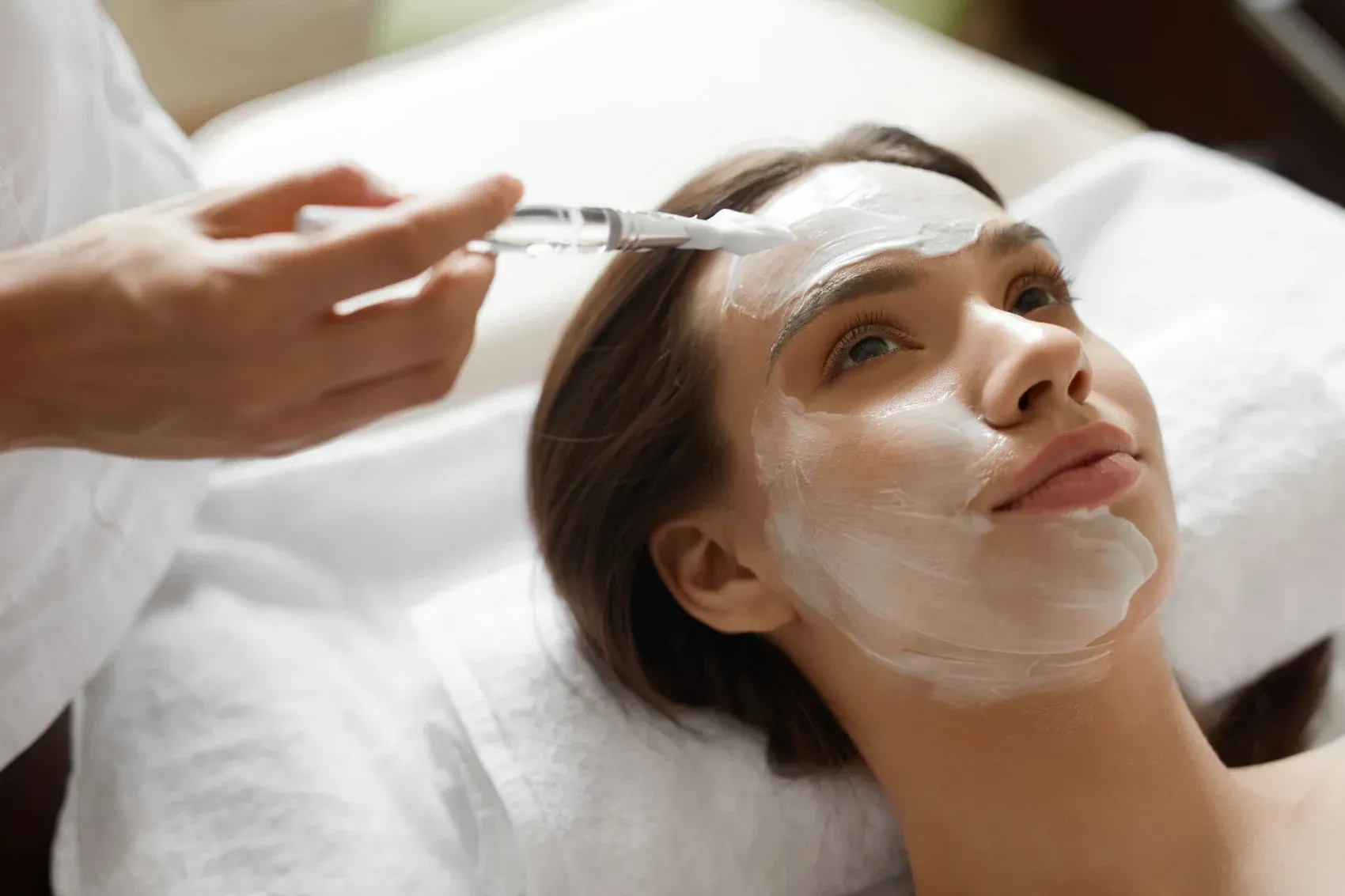 Una mujer está recibiendo un tratamiento facial en un spa.