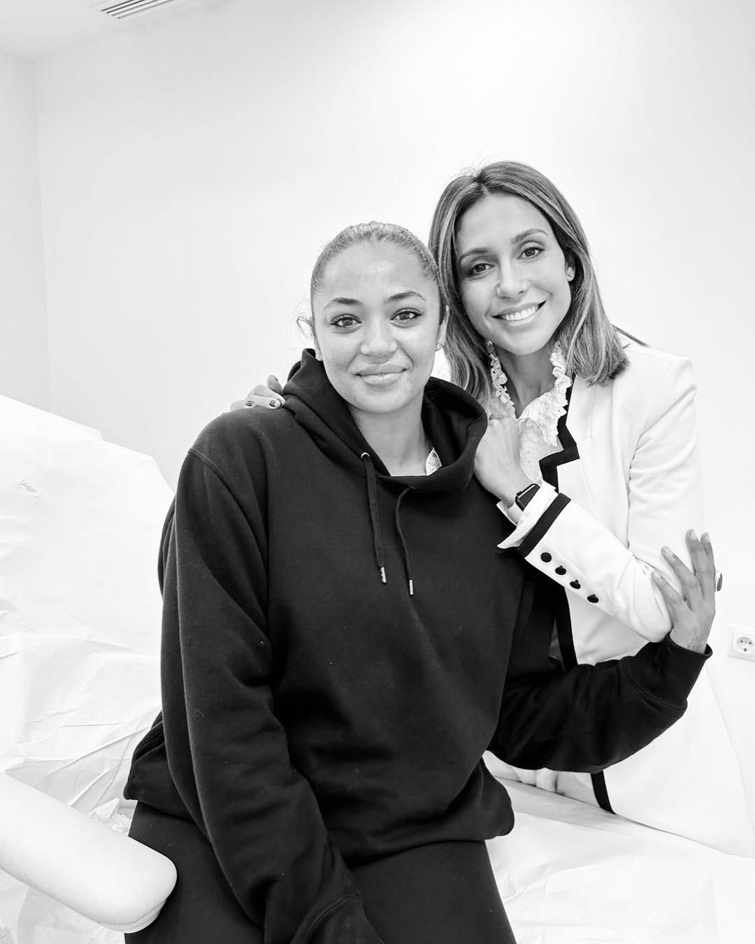 Una fotografía en blanco y negro de dos mujeres sentadas una al lado de la otra.