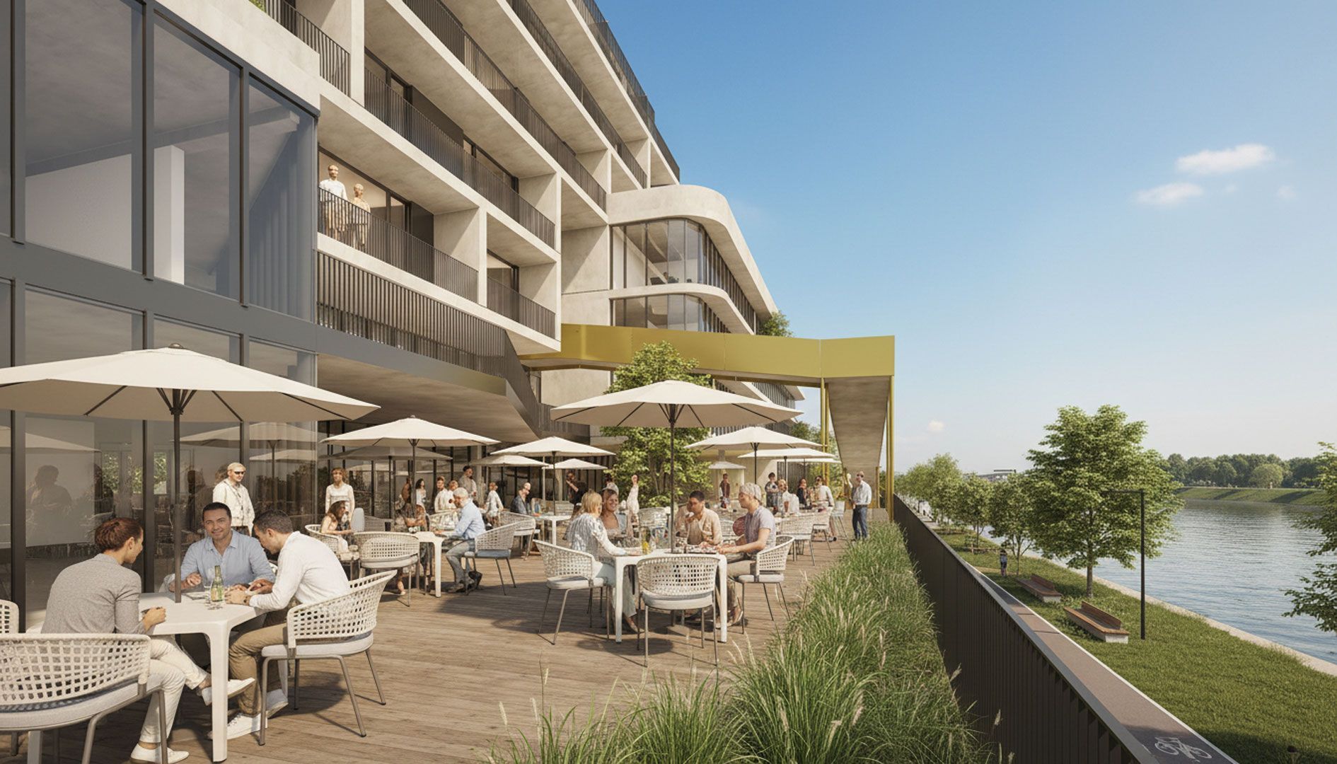 Restaurant en plein air au bord de l'eau ; des clients dînent à des tables ombragées, un bâtiment moderne se dresse en arrière-plan.