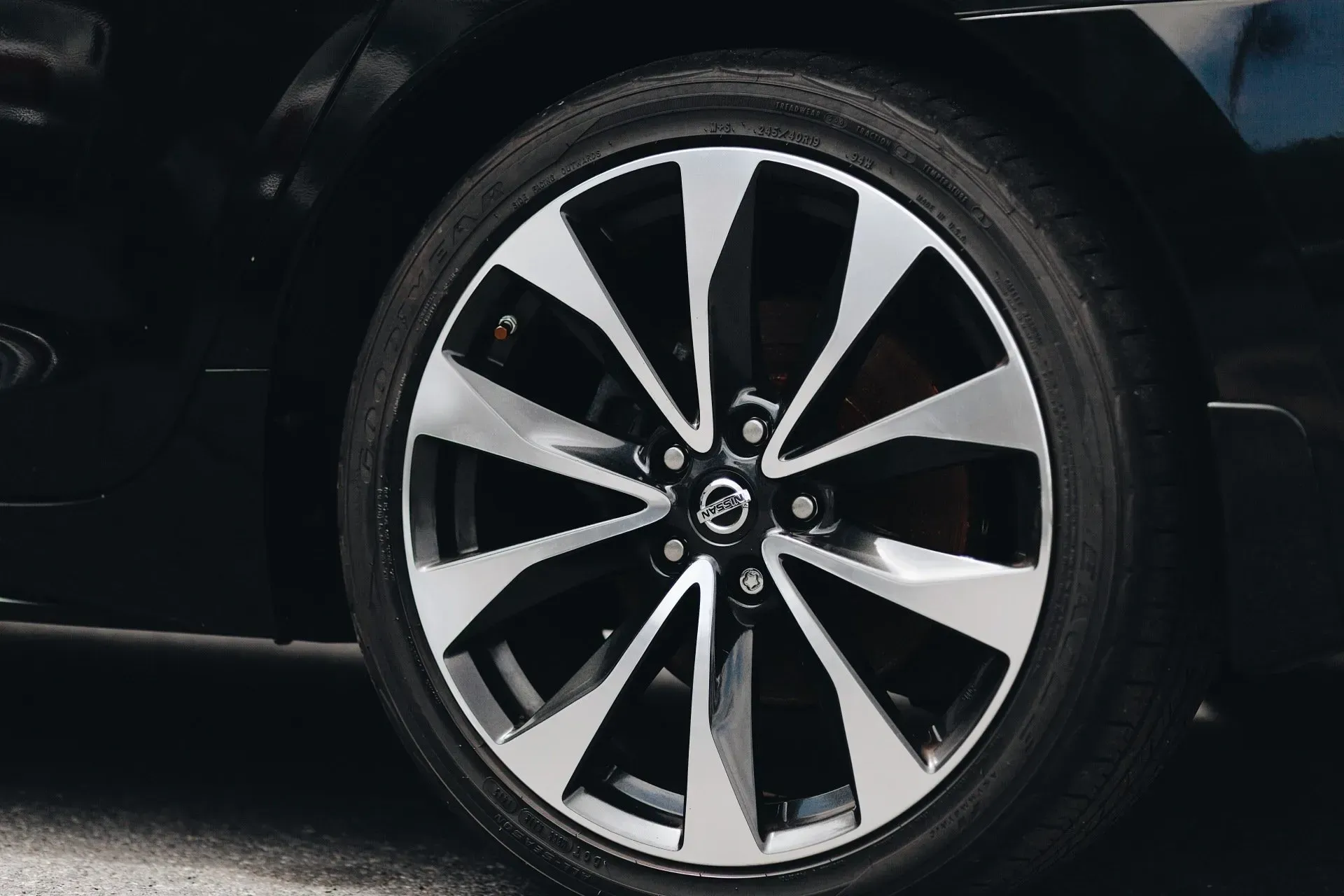 Gros plan sur une roue de voiture à rayons en alliage noir et argent, montée