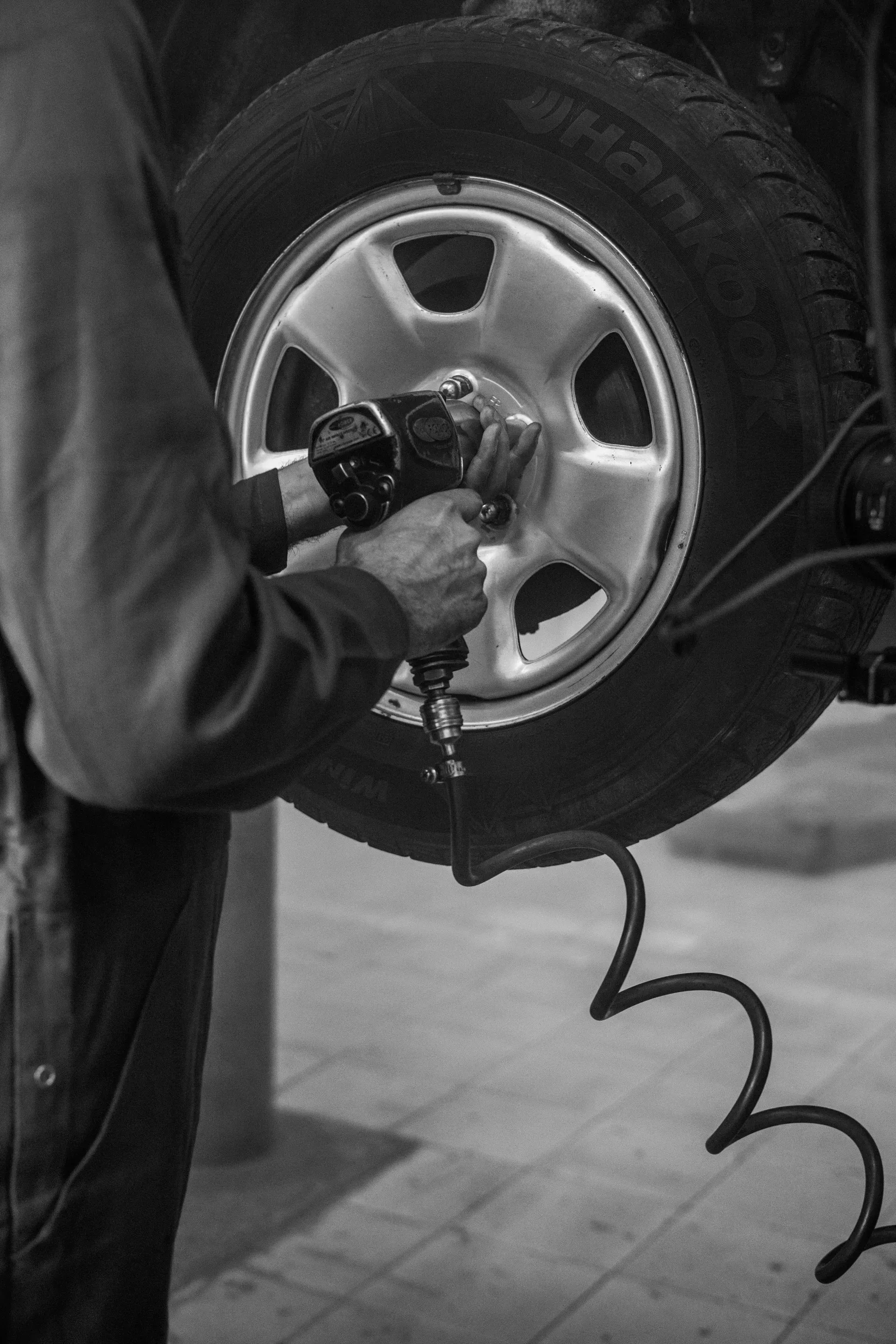Une personne utilise une clé à chocs pour serrer un pneu de voiture