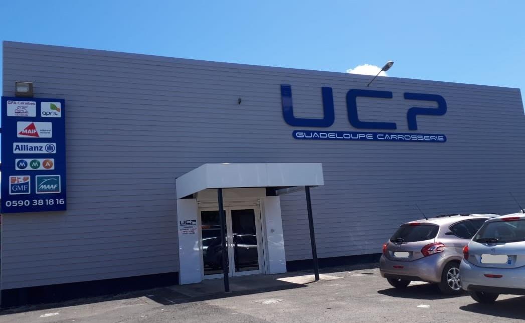 La devanture bleue de UCP Guadeloupe Carrosserie.