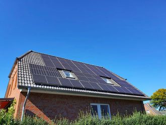 Ein Backsteinhaus mit Sonnenkollektoren auf dem Dach