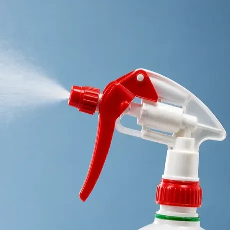 Boquilla de botella de spray roja y blanca sobre fondo azul