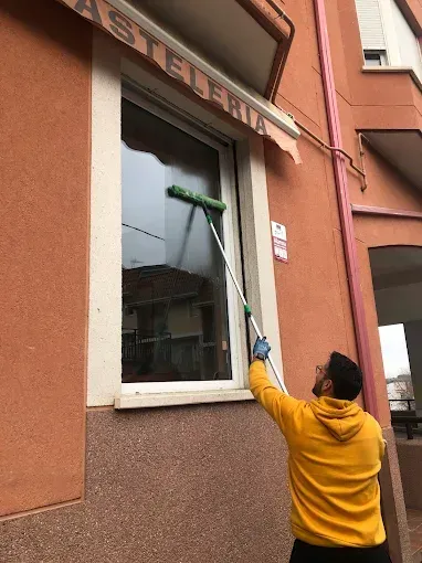 Una persona con una sudadera amarilla con capucha utiliza una escobilla