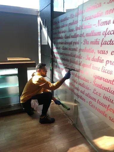 Una persona con una sudadera amarilla con capucha se arrodilla para colocar 