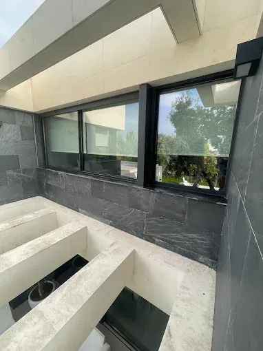 Espacio arquitectónico moderno con paredes revestidas de azulejos de piedra