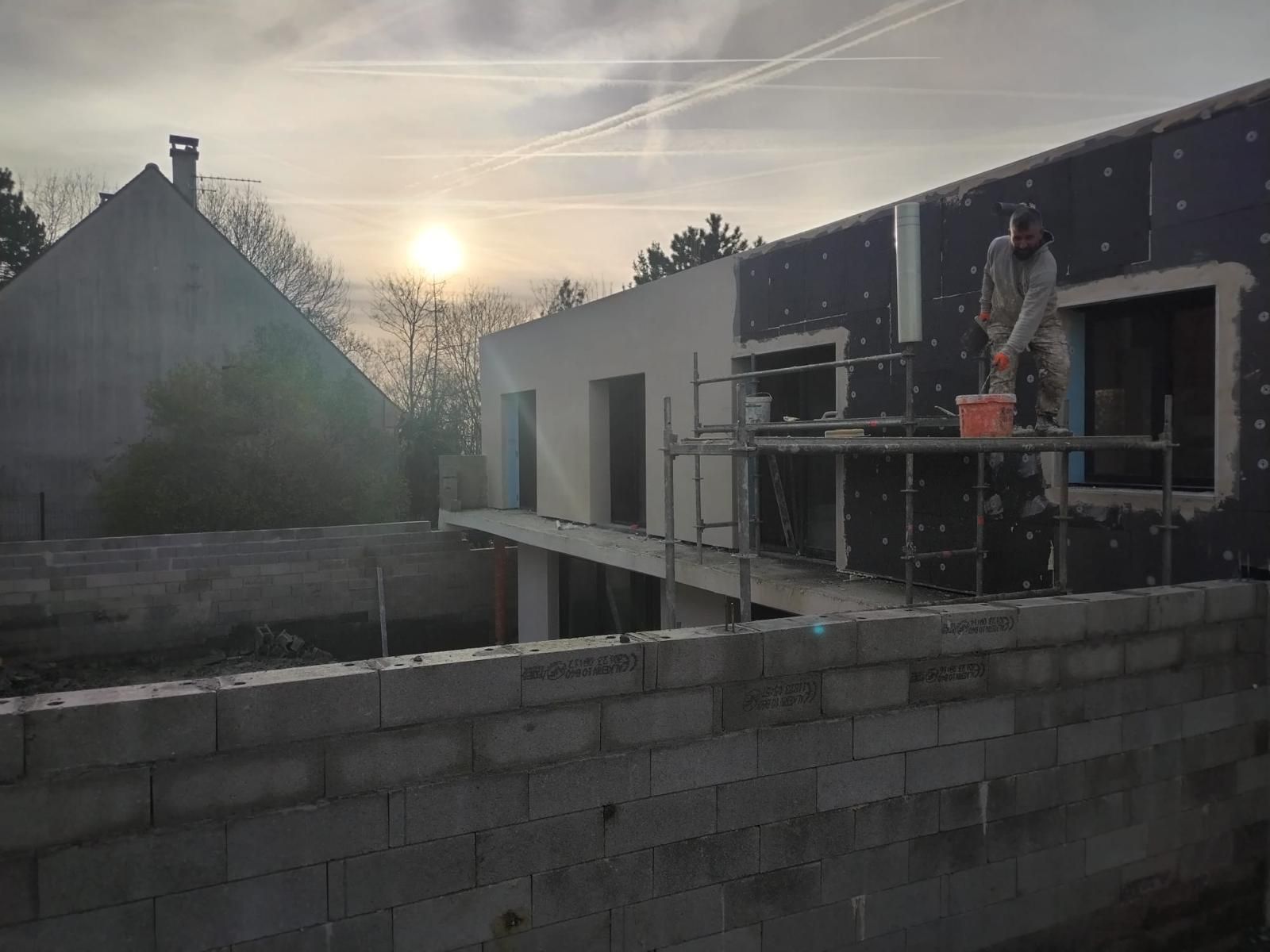 Un ouvrier travaille sur le chantier de construction d'une maison