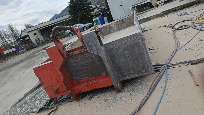 Une machine est posée sur le sol à côté d'un bâtiment.