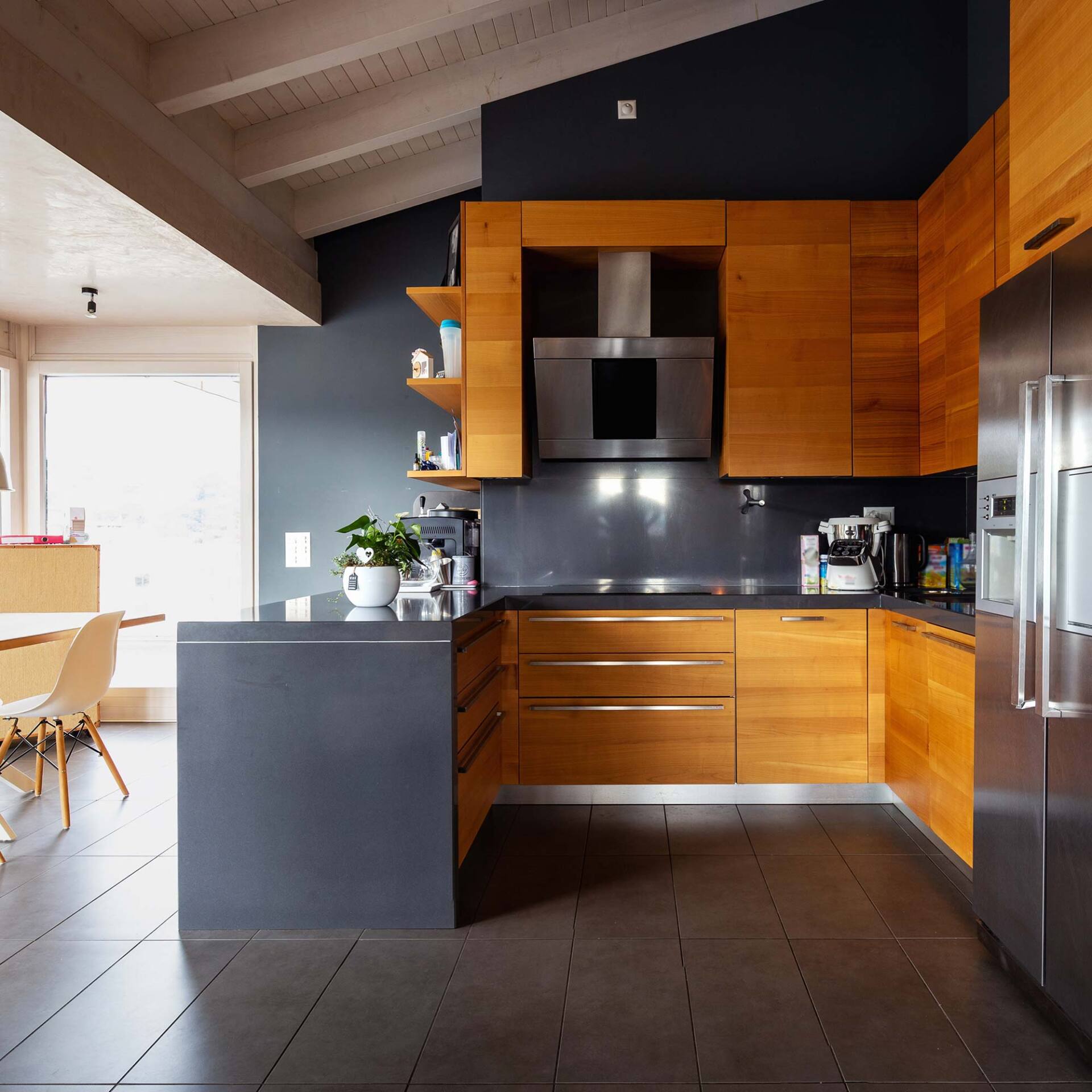 Cuisine comportant un sol en carrelage et des meubles avec une façade en bois