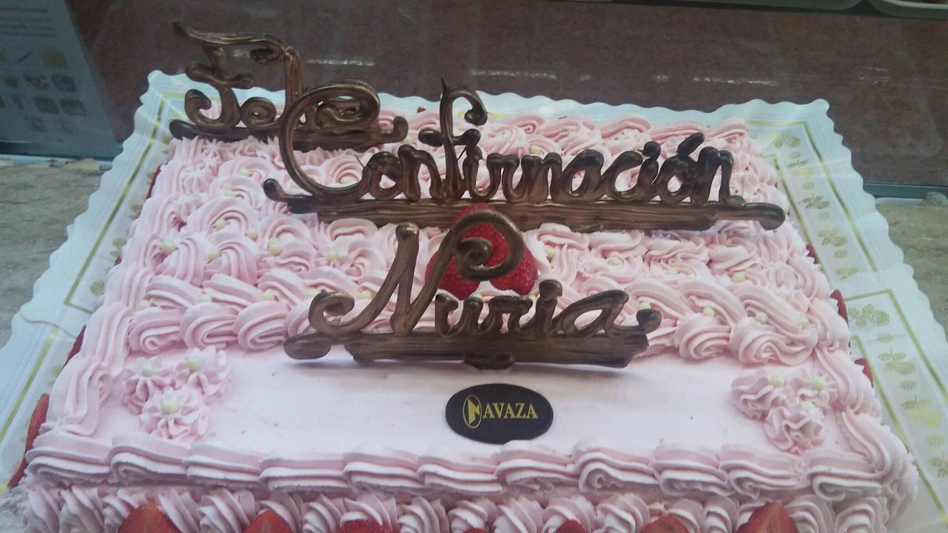Un pastel cuadrado rosa glaseado decorado