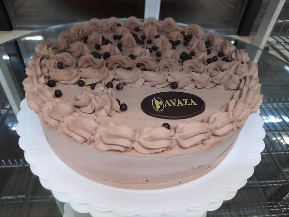 Un pastel redondo de chocolate con glaseado batido