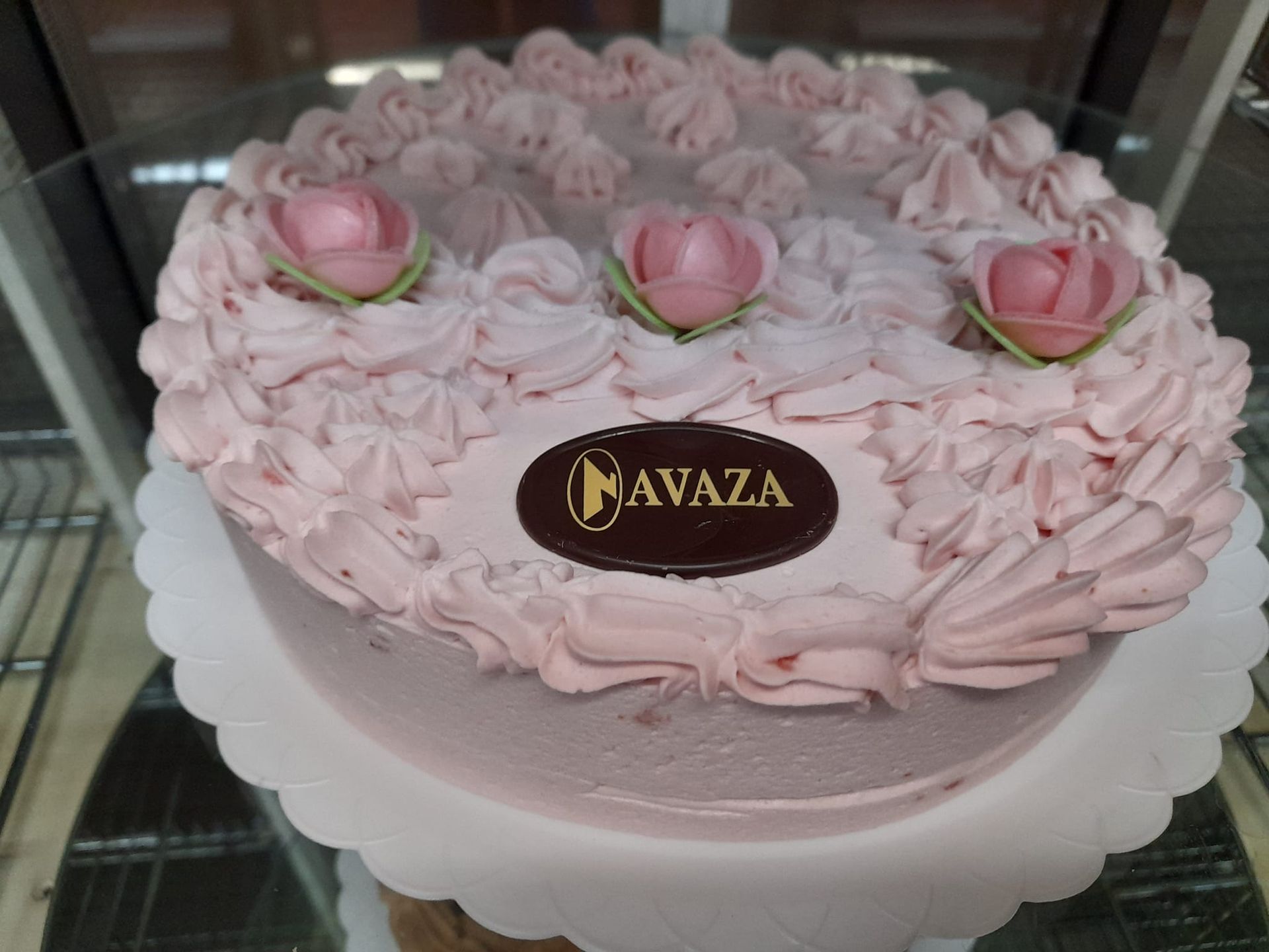 Un pastel redondo, cubierto de glaseado rosa