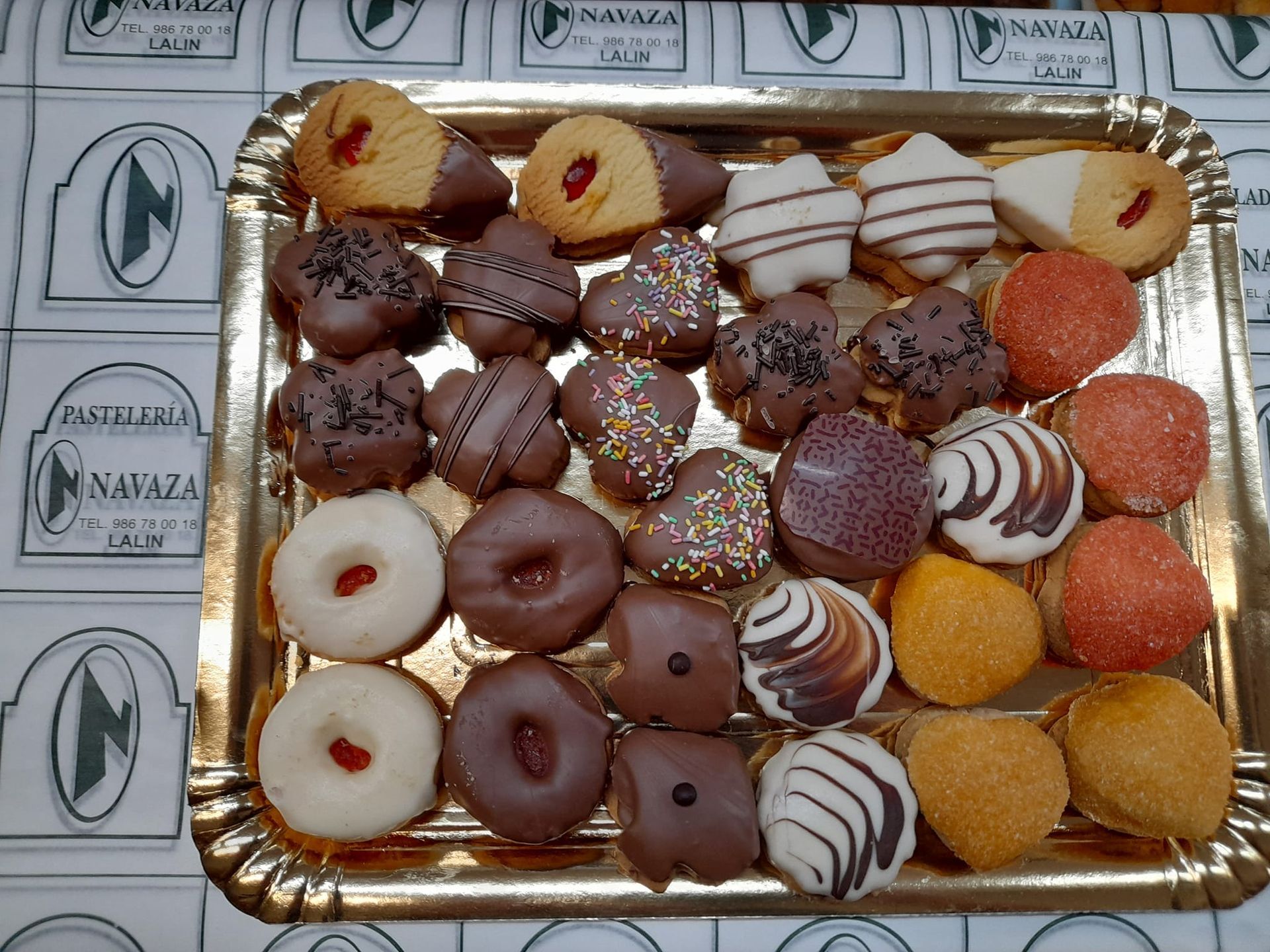 Una bandeja dorada repleta de una variedad de galletas