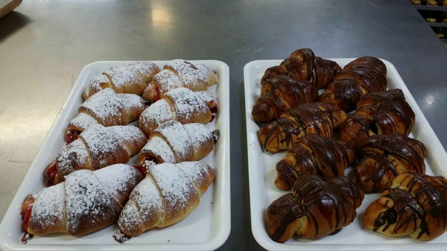 Dos bandejas blancas de croissants recién horneados