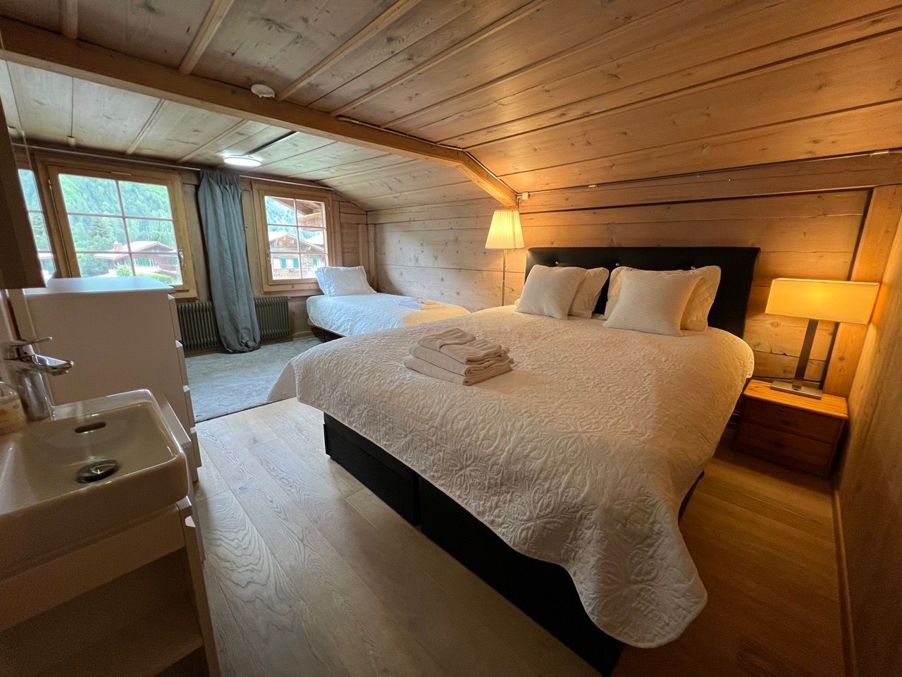 A bedroom with a large bed and a sink.